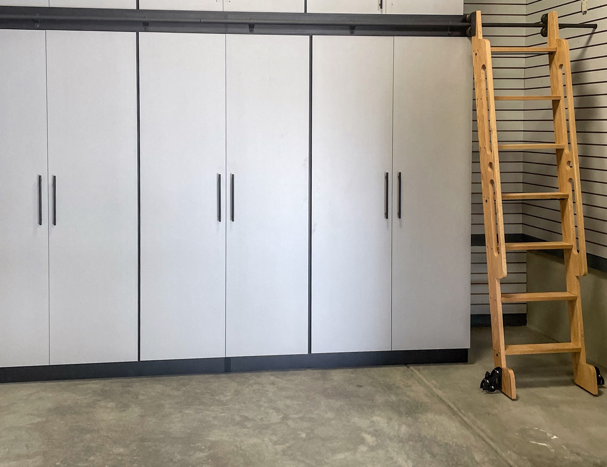 Park City garage with laddered cabinet system, slatwall, and overhead storage